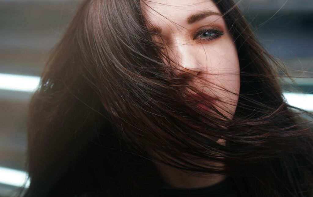 Frau mit glänzendem, dunklem Haar – der typische Effekt eines Hair Gloss