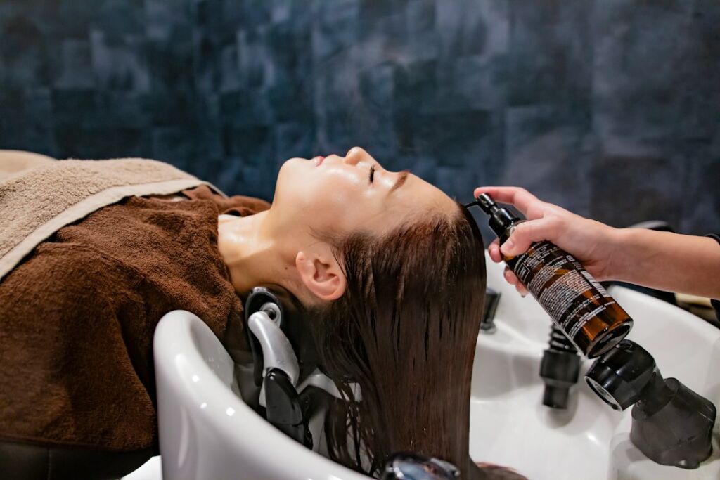 Haarbotox-Wirkstoff wird am Waschbecken auf das Haar aufgetragen